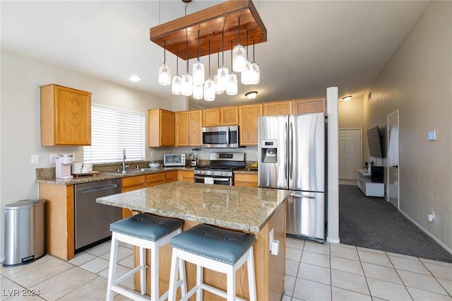 kitchen featuring pendant lighting, sink, a kitchen island, light colored carpet, and stainless steel appliances