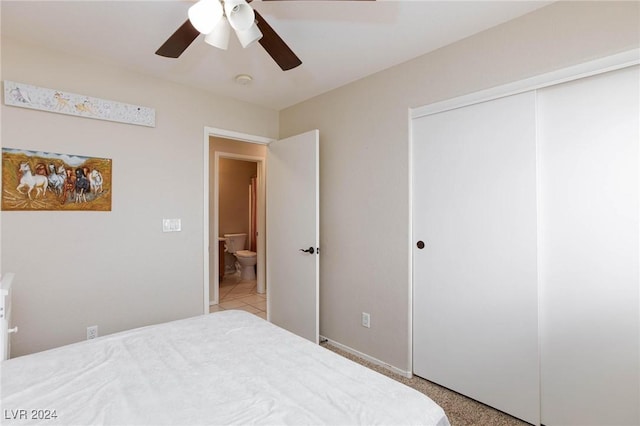 carpeted bedroom with ceiling fan, ensuite bathroom, and a closet