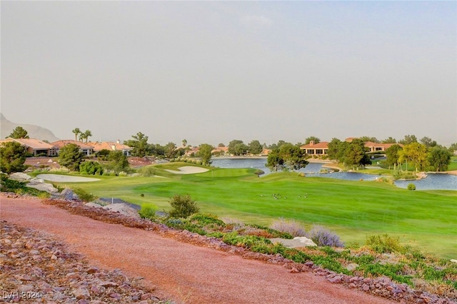 view of property's community with a lawn and a water view