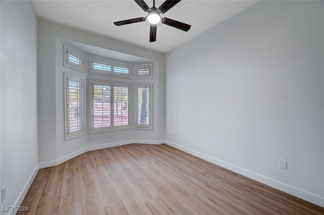 empty room with ceiling fan and light hardwood / wood-style floors