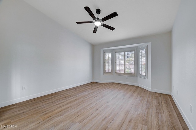 empty room with ceiling fan, vaulted ceiling, and light hardwood / wood-style flooring