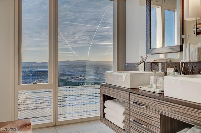 bathroom with tile patterned floors, a mountain view, vanity, and a healthy amount of sunlight