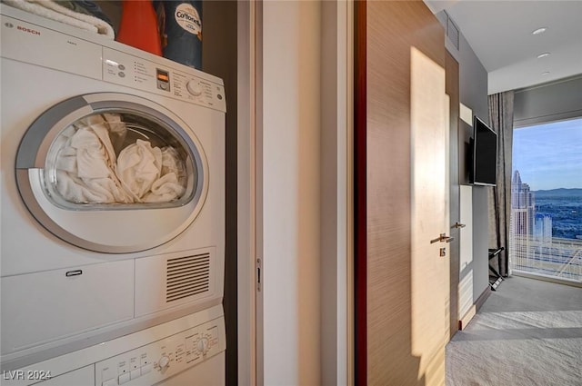 laundry room with stacked washing maching and dryer