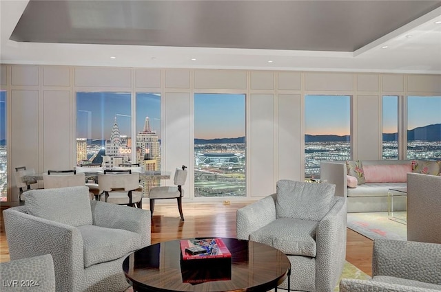 living room featuring a tray ceiling and light hardwood / wood-style flooring