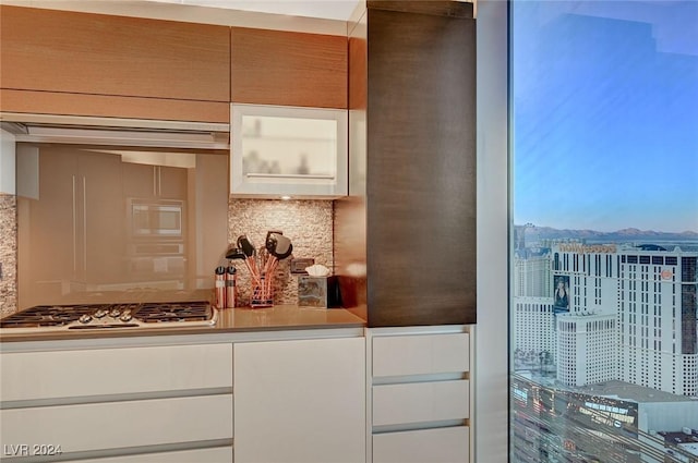 kitchen with stainless steel gas stovetop and backsplash