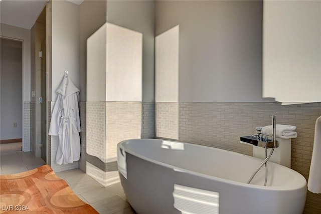 bathroom with tile patterned floors, a bath, and tile walls