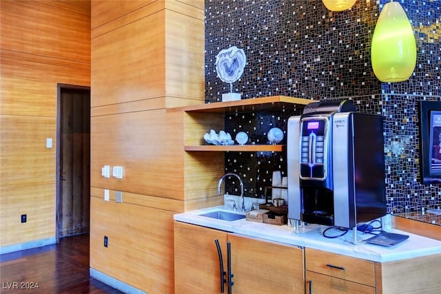 bar featuring backsplash, sink, and dark wood-type flooring