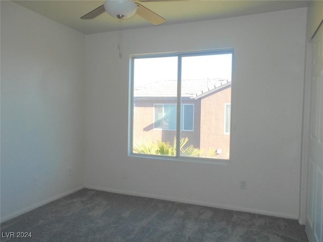 carpeted empty room with ceiling fan and plenty of natural light