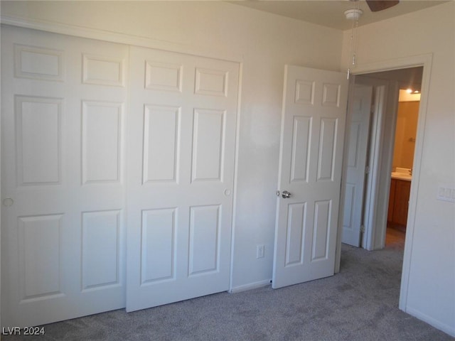 unfurnished bedroom featuring carpet flooring, ceiling fan, and a closet