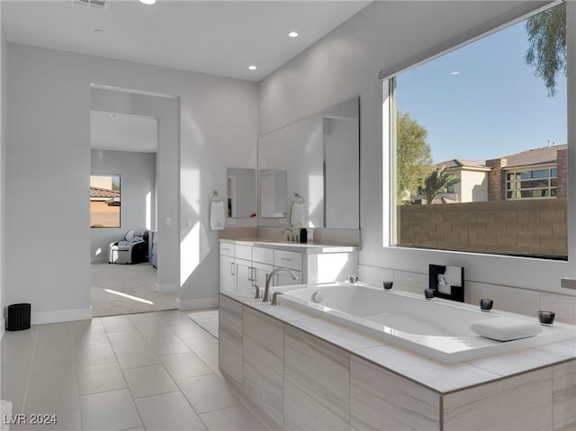 bathroom with tile patterned floors, vanity, and tiled tub