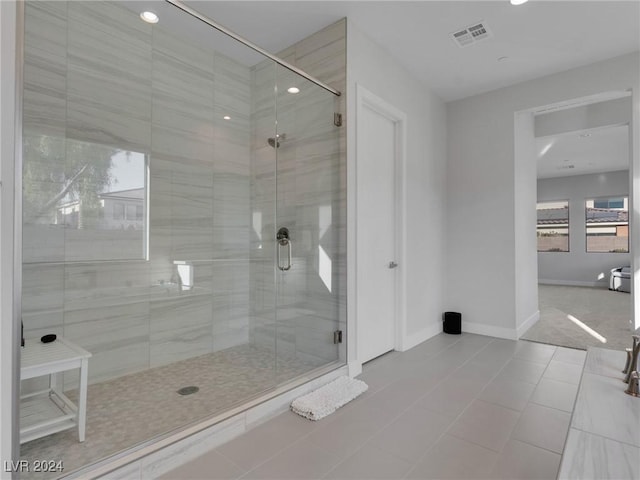 bathroom with tile patterned flooring and a shower with shower door