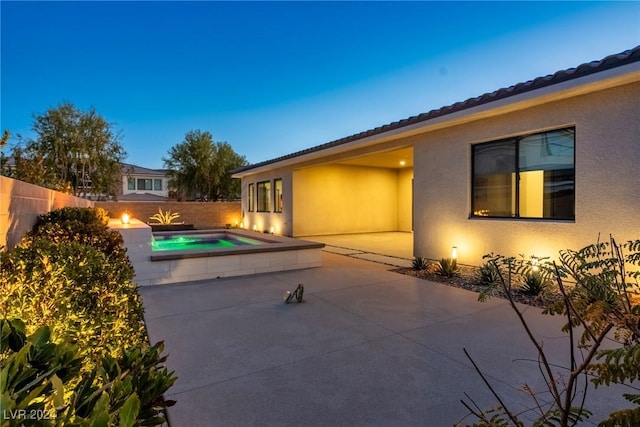 pool at dusk with a patio