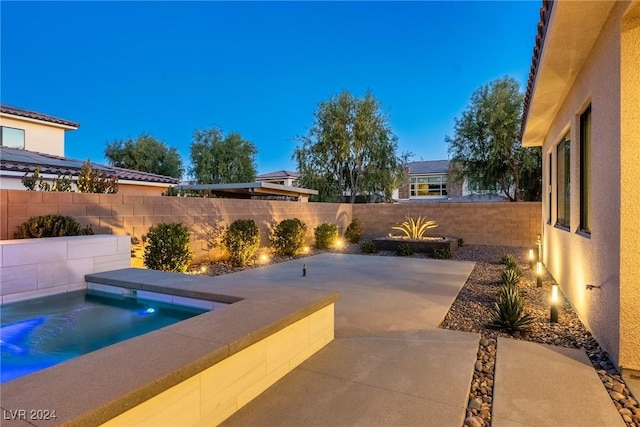 pool at dusk with a patio