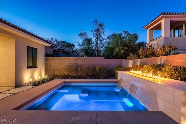 pool at dusk with pool water feature