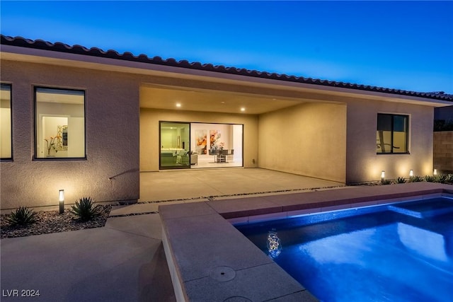 pool at dusk with a patio