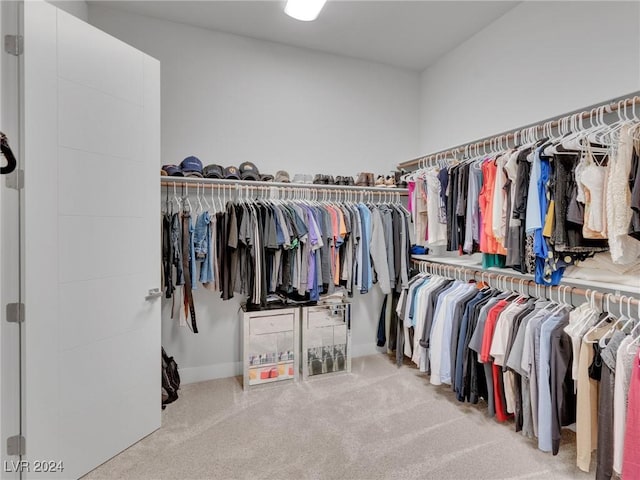 walk in closet featuring light colored carpet