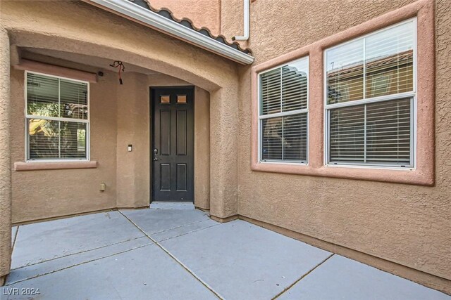 view of exterior entry featuring a patio