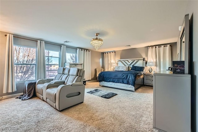 bedroom with a notable chandelier and light colored carpet