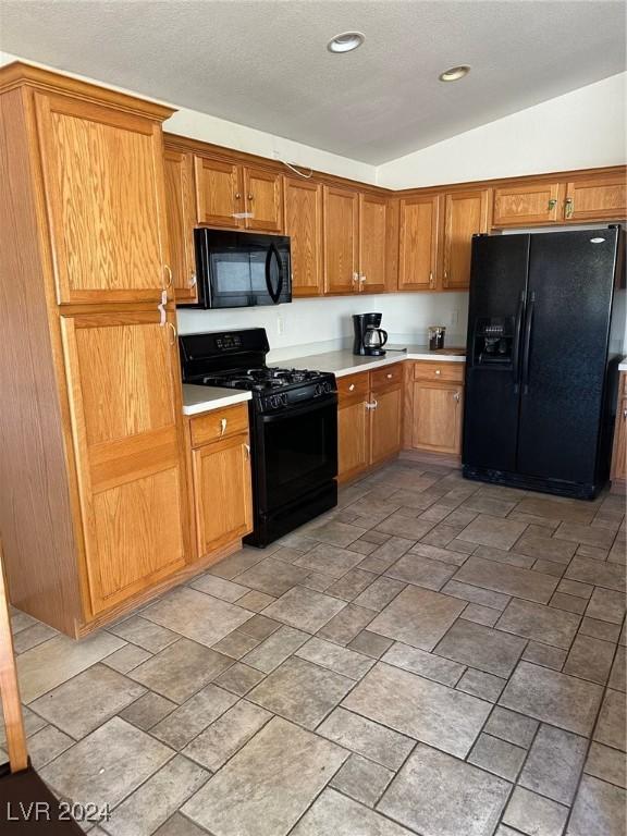 kitchen featuring black appliances and vaulted ceiling