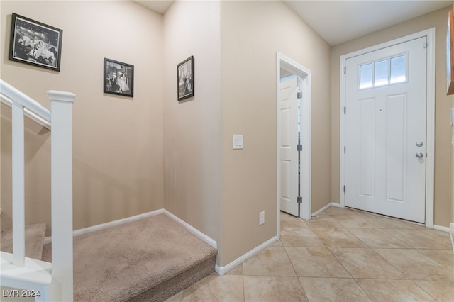 entryway featuring light tile patterned floors, stairway, and baseboards