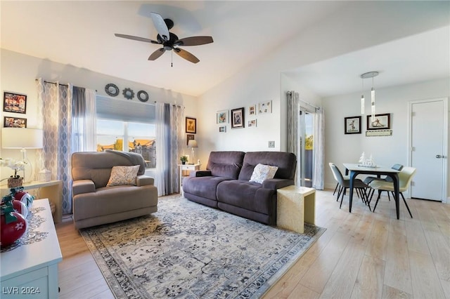 living room featuring ceiling fan, light hardwood / wood-style floors, and vaulted ceiling