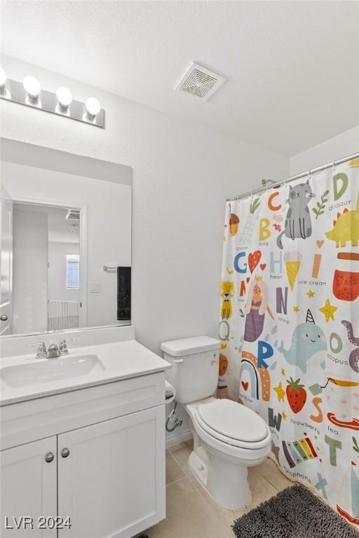 bathroom with curtained shower, tile patterned flooring, vanity, and toilet