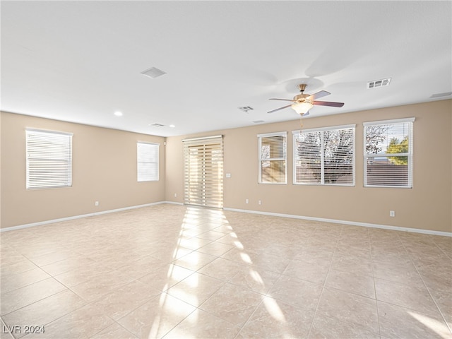 tiled spare room with plenty of natural light and ceiling fan