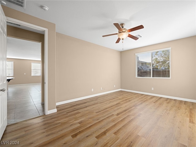 empty room with light hardwood / wood-style flooring and ceiling fan