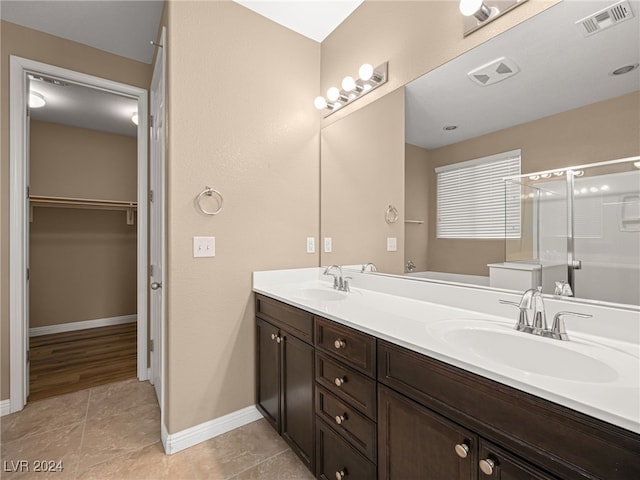 bathroom featuring tile patterned flooring, vanity, and walk in shower