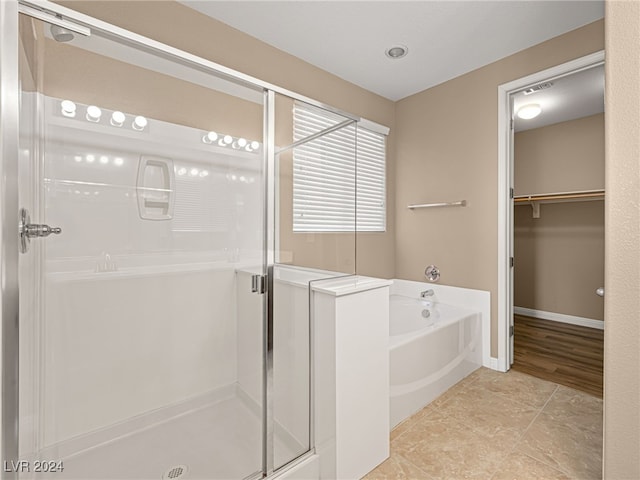 bathroom featuring tile patterned flooring and separate shower and tub