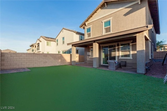 back of house featuring a patio area, a fenced backyard, a lawn, and stucco siding