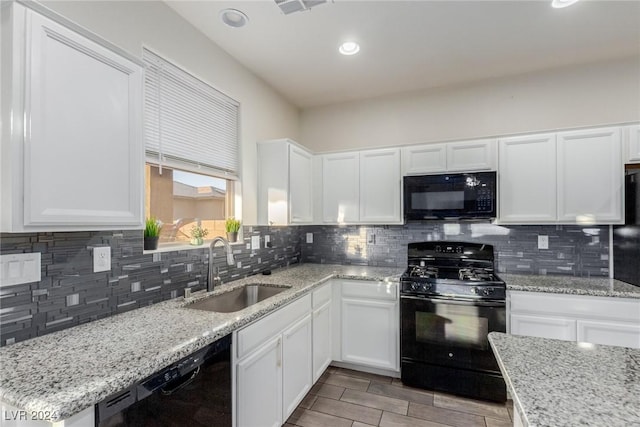 kitchen featuring black appliances, tasteful backsplash, white cabinetry, and a sink