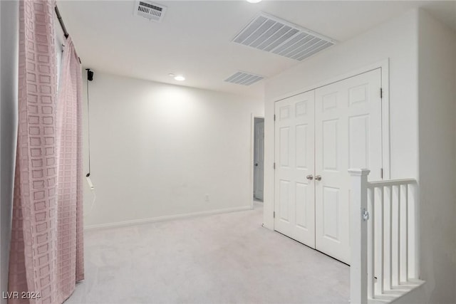 corridor featuring baseboards, visible vents, and carpet flooring