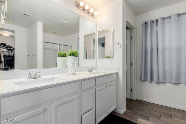 bathroom with a stall shower, a sink, visible vents, and wood tiled floor