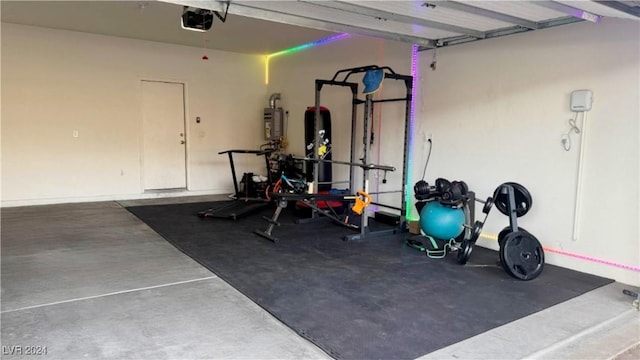 exercise room with a garage and water heater