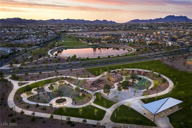 aerial view at dusk featuring a water and mountain view