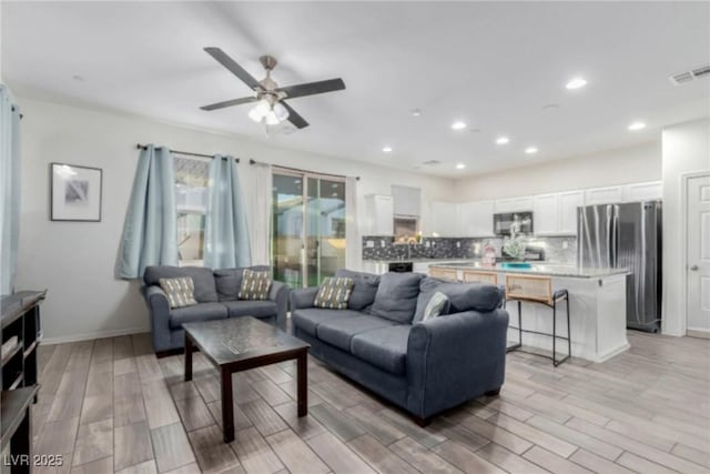 living room with a ceiling fan, recessed lighting, visible vents, and light wood-style flooring