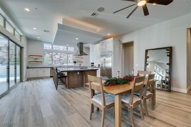 dining room with ceiling fan, a healthy amount of sunlight, and light wood-type flooring