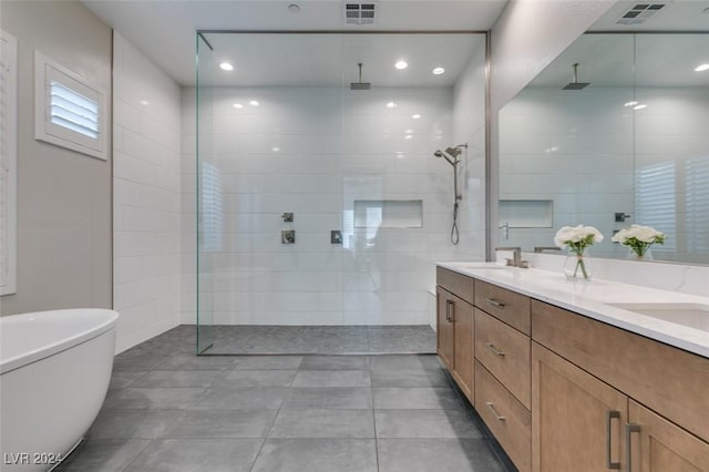 bathroom featuring tile patterned flooring, vanity, and tiled shower