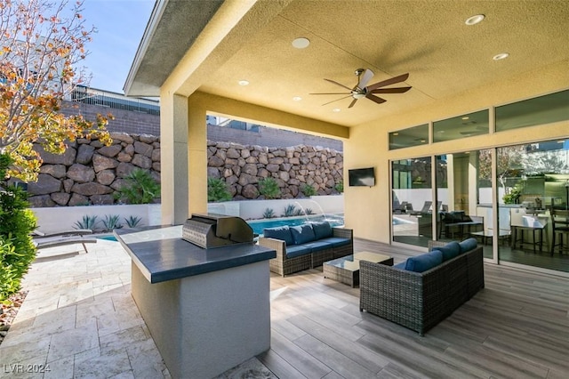 view of patio featuring ceiling fan, area for grilling, an outdoor hangout area, and a wooden deck