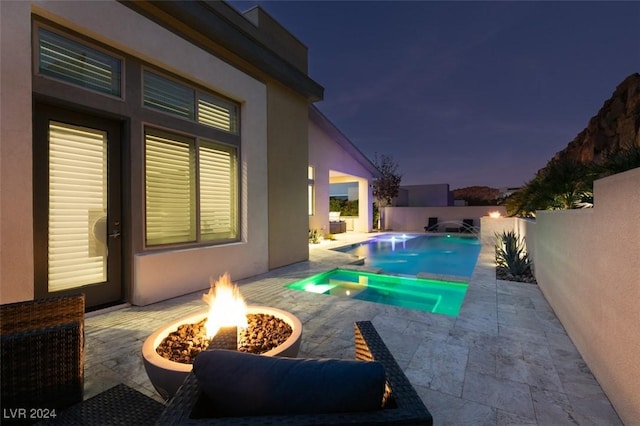 view of swimming pool with pool water feature, a patio, and a fire pit