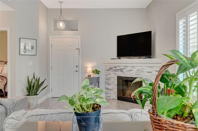 living room featuring a stone fireplace and light wood-type flooring