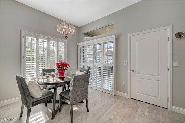 dining space featuring light hardwood / wood-style floors and an inviting chandelier