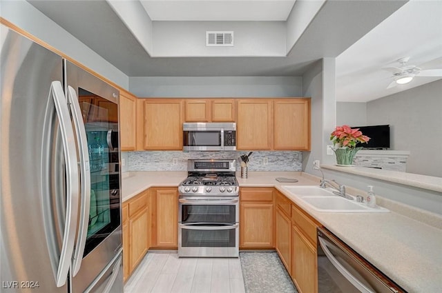 kitchen with light brown cabinets, sink, decorative backsplash, ceiling fan, and appliances with stainless steel finishes