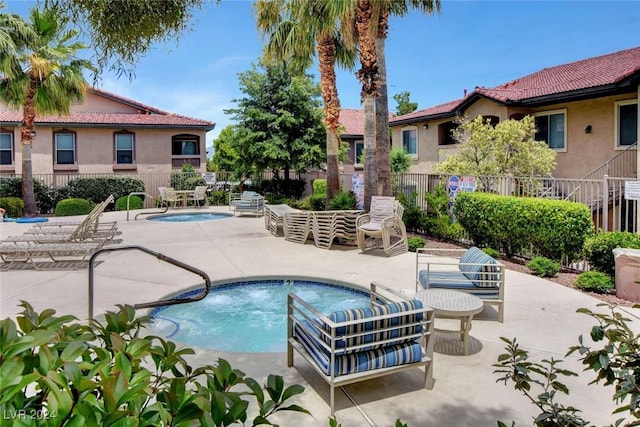 view of swimming pool featuring a patio and a hot tub