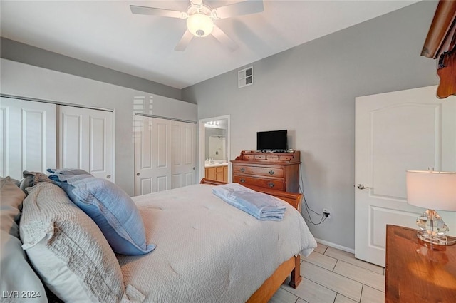 bedroom with connected bathroom, ceiling fan, and multiple closets