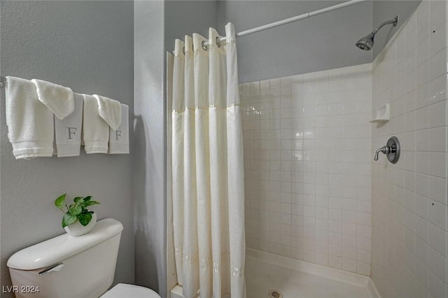 bathroom with curtained shower and toilet