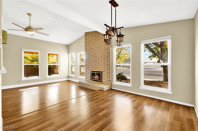 unfurnished living room with hardwood / wood-style flooring, vaulted ceiling with beams, and a wealth of natural light