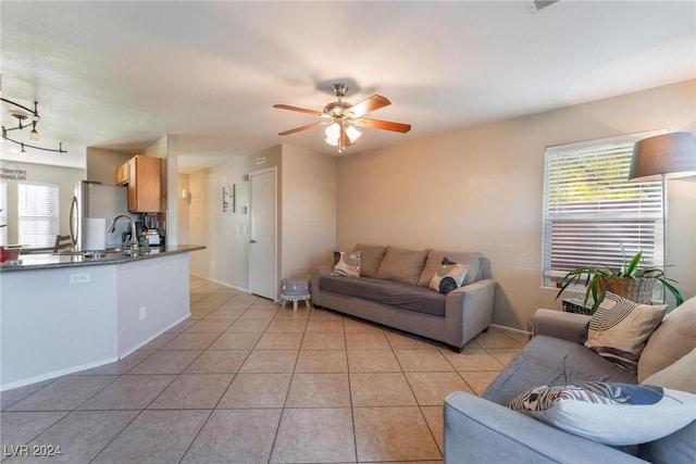 tiled living room featuring ceiling fan and a healthy amount of sunlight