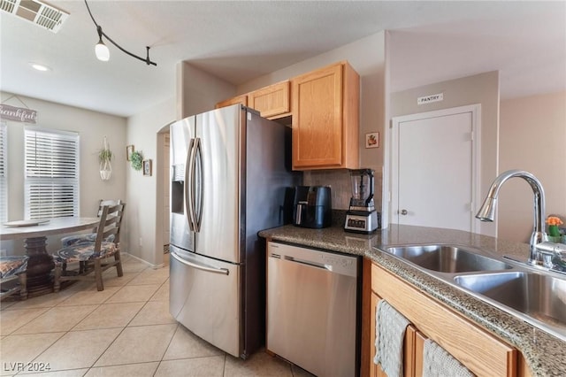 kitchen with light tile patterned floors, stainless steel appliances, and sink